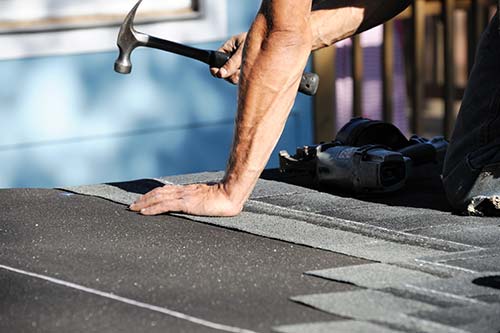 Roofing contractor working on shingle roof